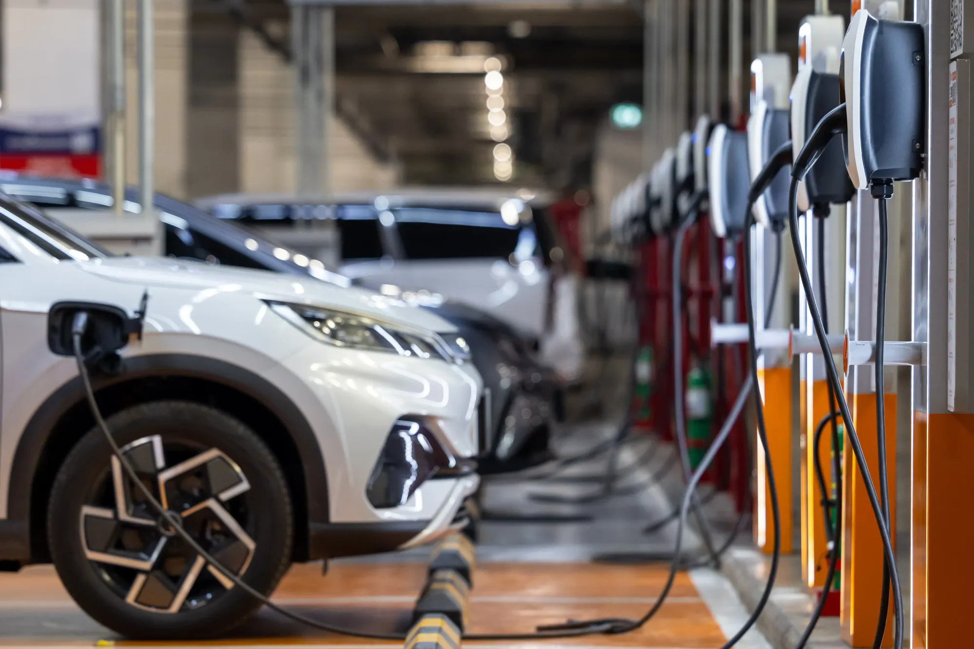 Weißes Elektroauto an einer Ladestation.